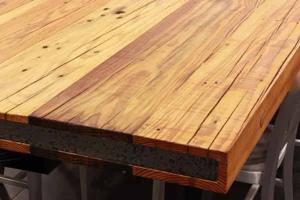 A close up of a reclaimed heart pine table top corner section.