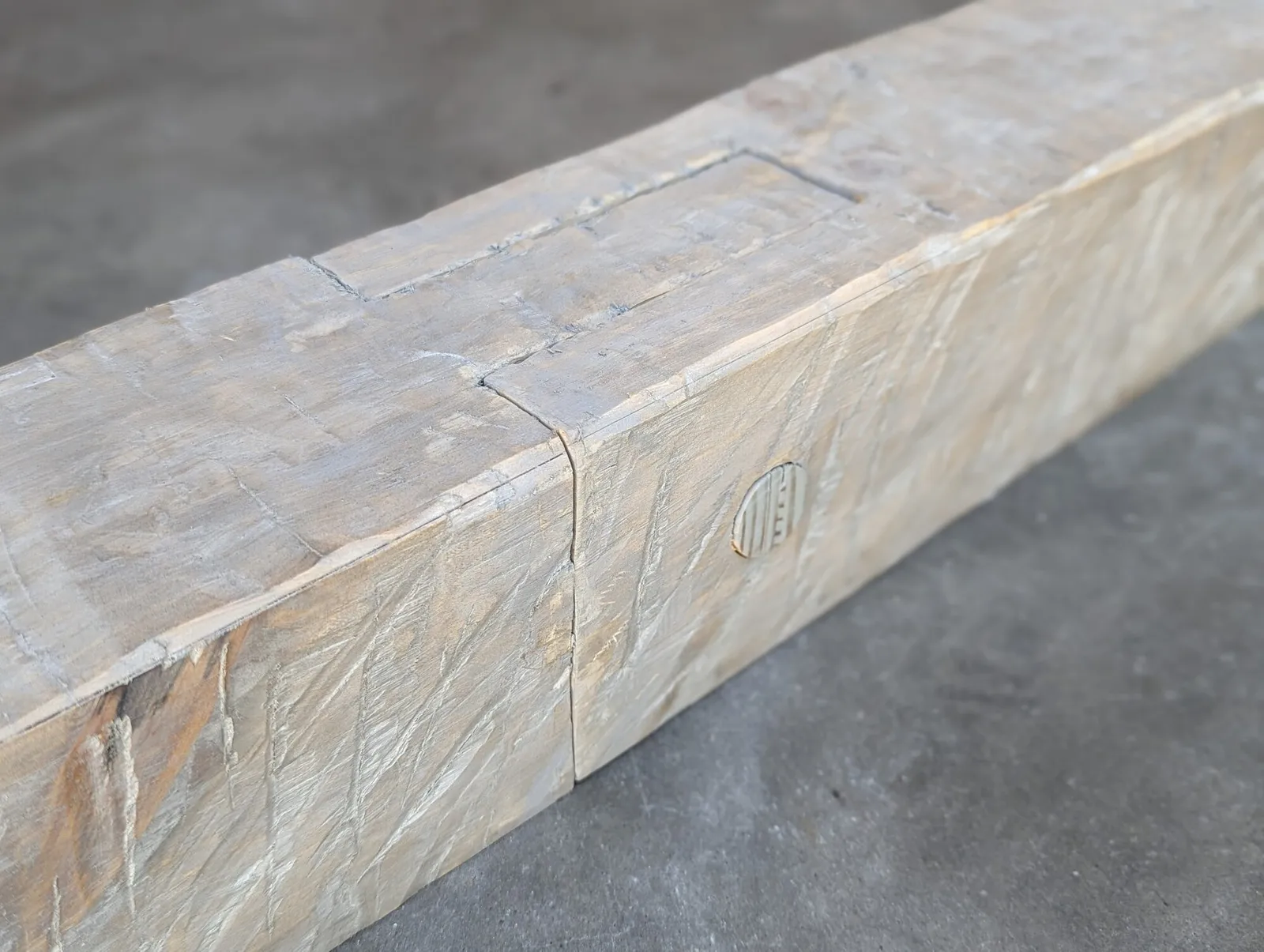 Hand-hewn white oak box beam with a weathered grey finish and a branded maker mark